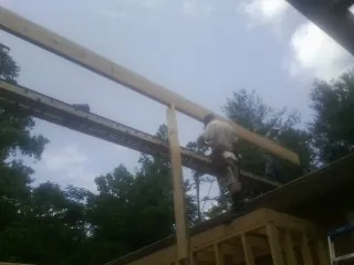 Carpenter setting a ridge beam over a new addition frame — Ice Dam Removal by Roofing Brothers in La Crescenta