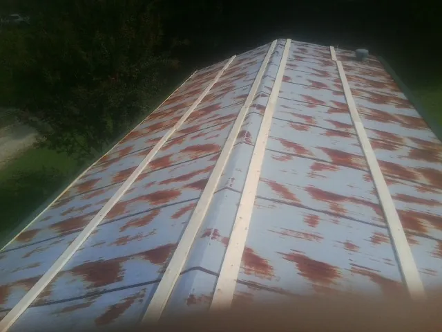 Rusted metal roof panels with new wood purlins before replacement in La Crescenta