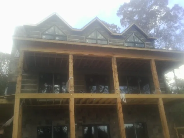 Dormers and porch framing on a large log home under construction — Roof Coating work by our crew in La Crescenta