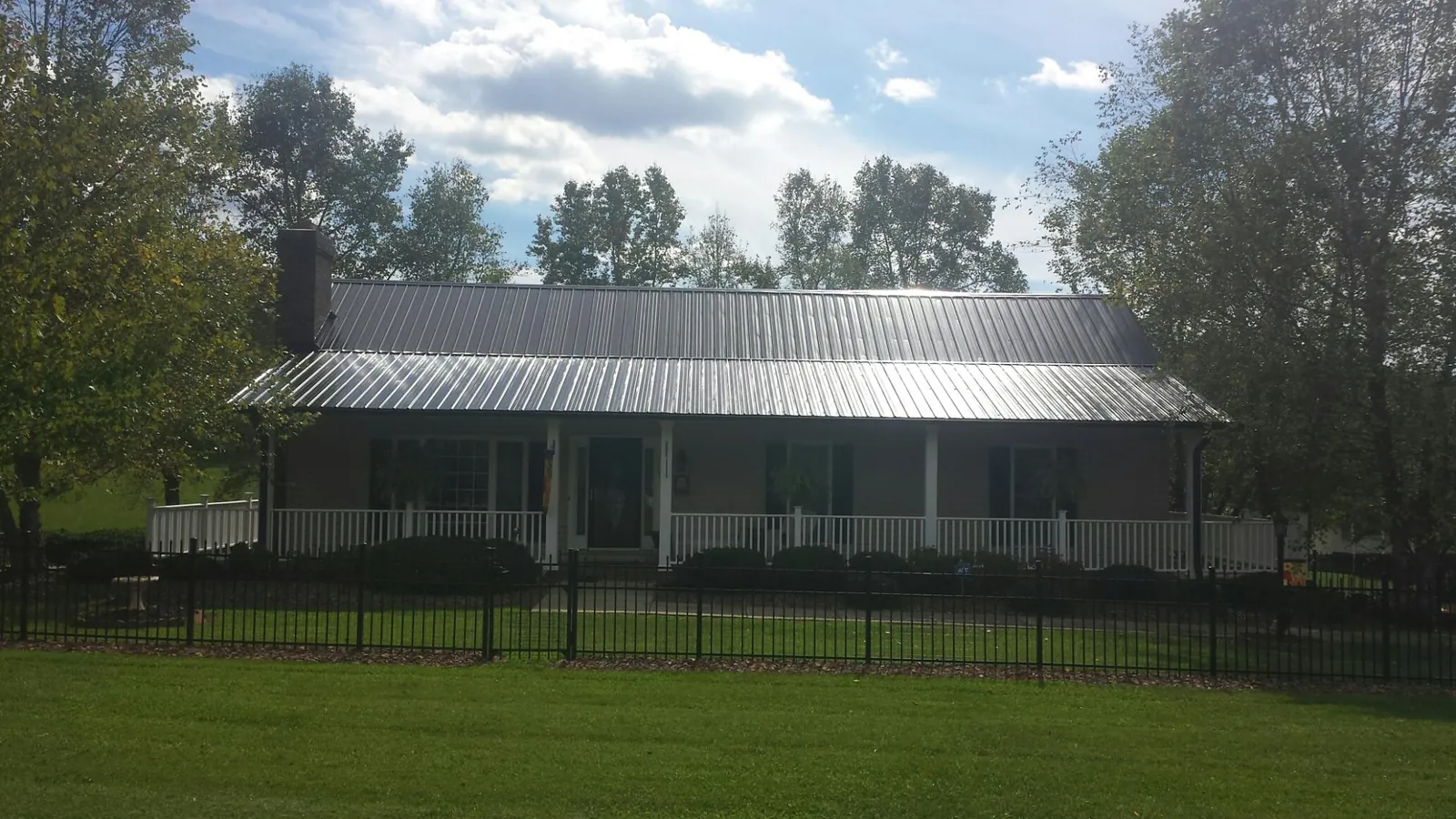 Gray metal roof on a brick ranch with a full width front porch — Gutter Guard Installation work by our crew in La Crescenta